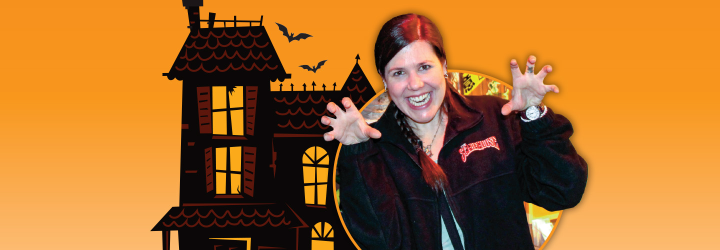 Person making a scary gesture with their face and hands with a haunted house backdrop