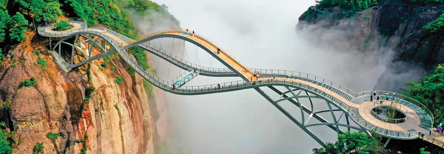 Aerial view image of a bridge with a high arch in a mountain landscape