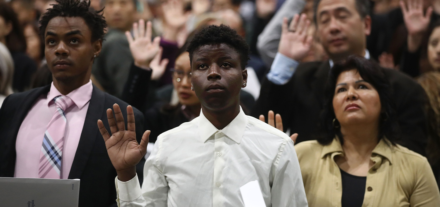 A group of people hold their right hands ap.